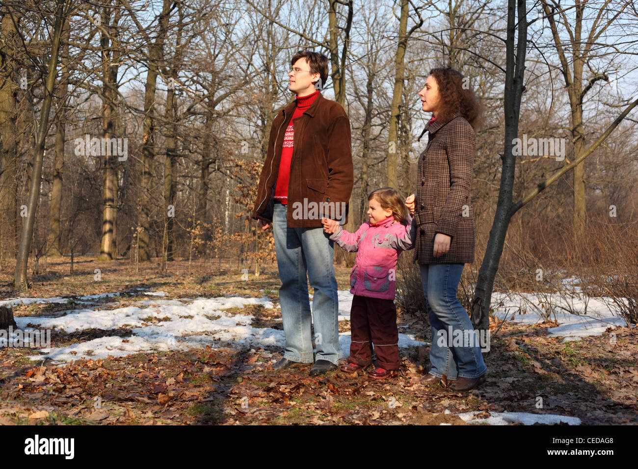 Famiglia con la figlia nella primavera del legno con ultima neve Foto Stock