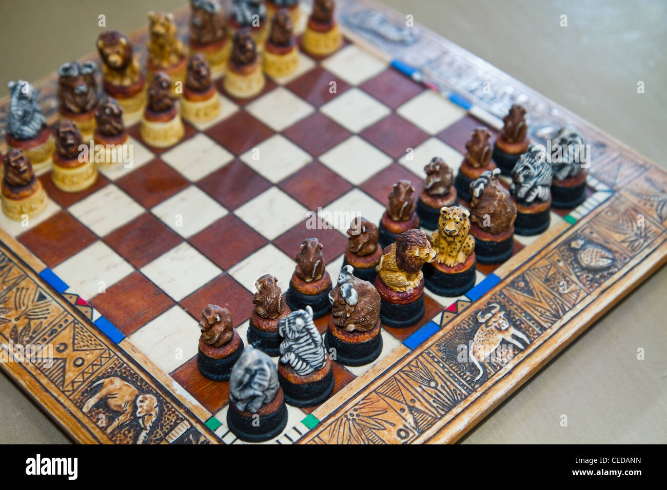 Safari gioco di scacchi - Scacchiera e uomo - DECORO SCACCHIERA decorato con safari figure di animali Foto Stock