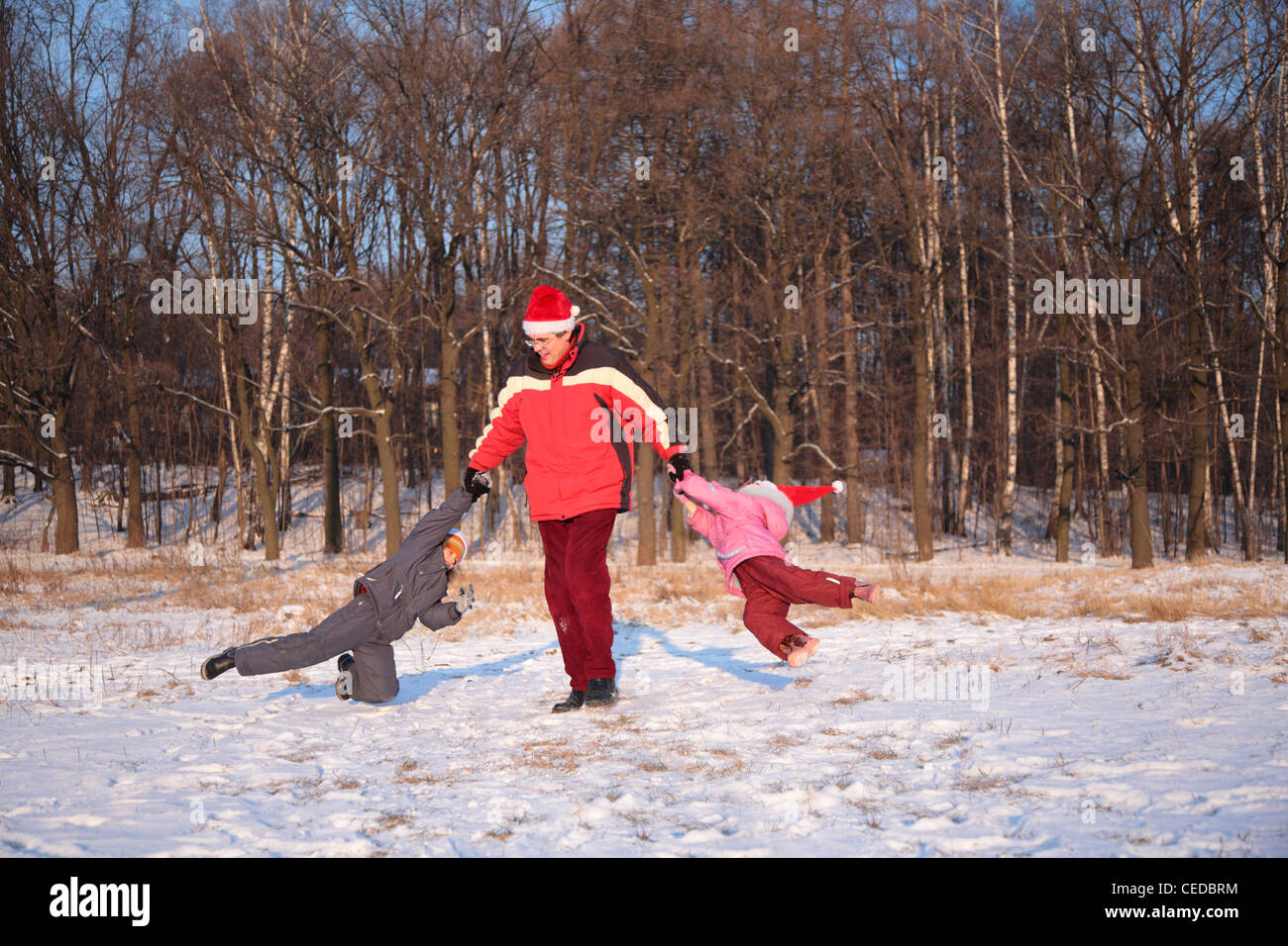 Padre ruotare i bambini in legno in inverno Foto Stock
