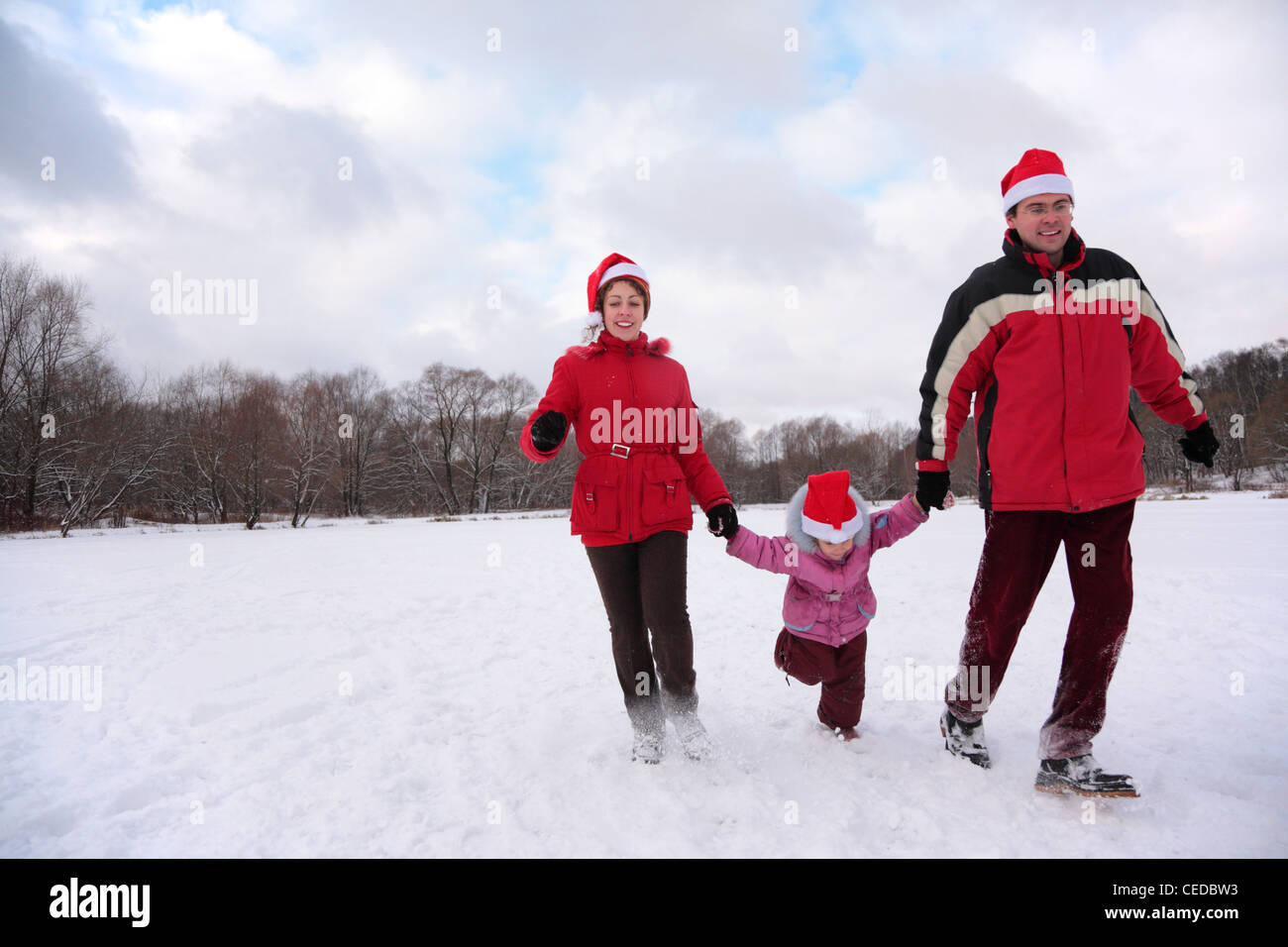 I genitori con bambino correre nel parco in inverno Foto Stock