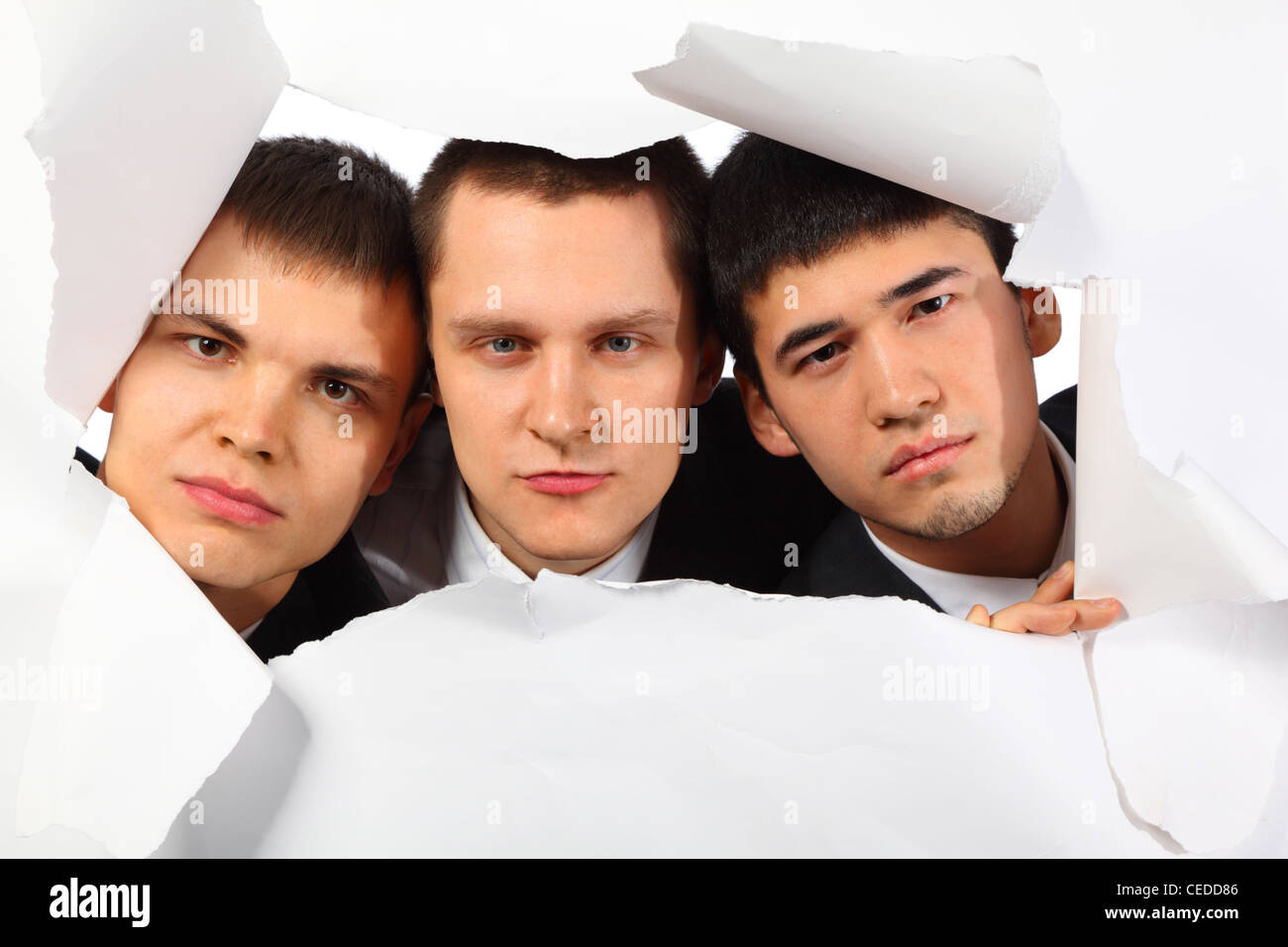 Tre giovani uomini guardando fuori nel foro della carta Foto Stock