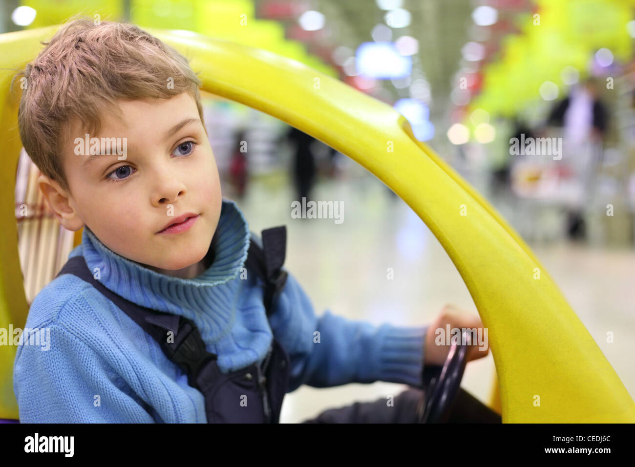 Ragazzo sittingn nel carro del mercato Foto Stock