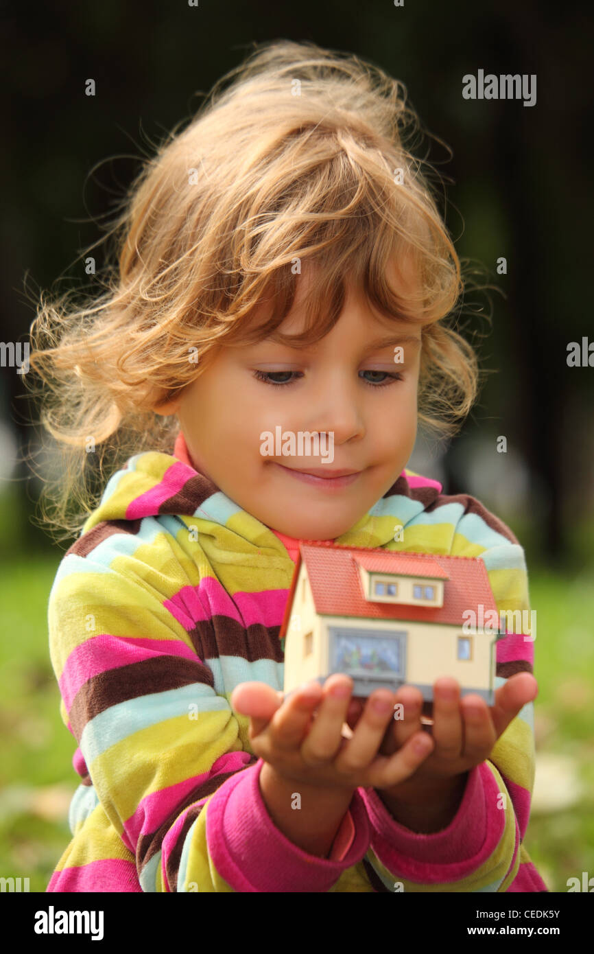 Bambina con toy piccola casa in mani outdoor Foto Stock