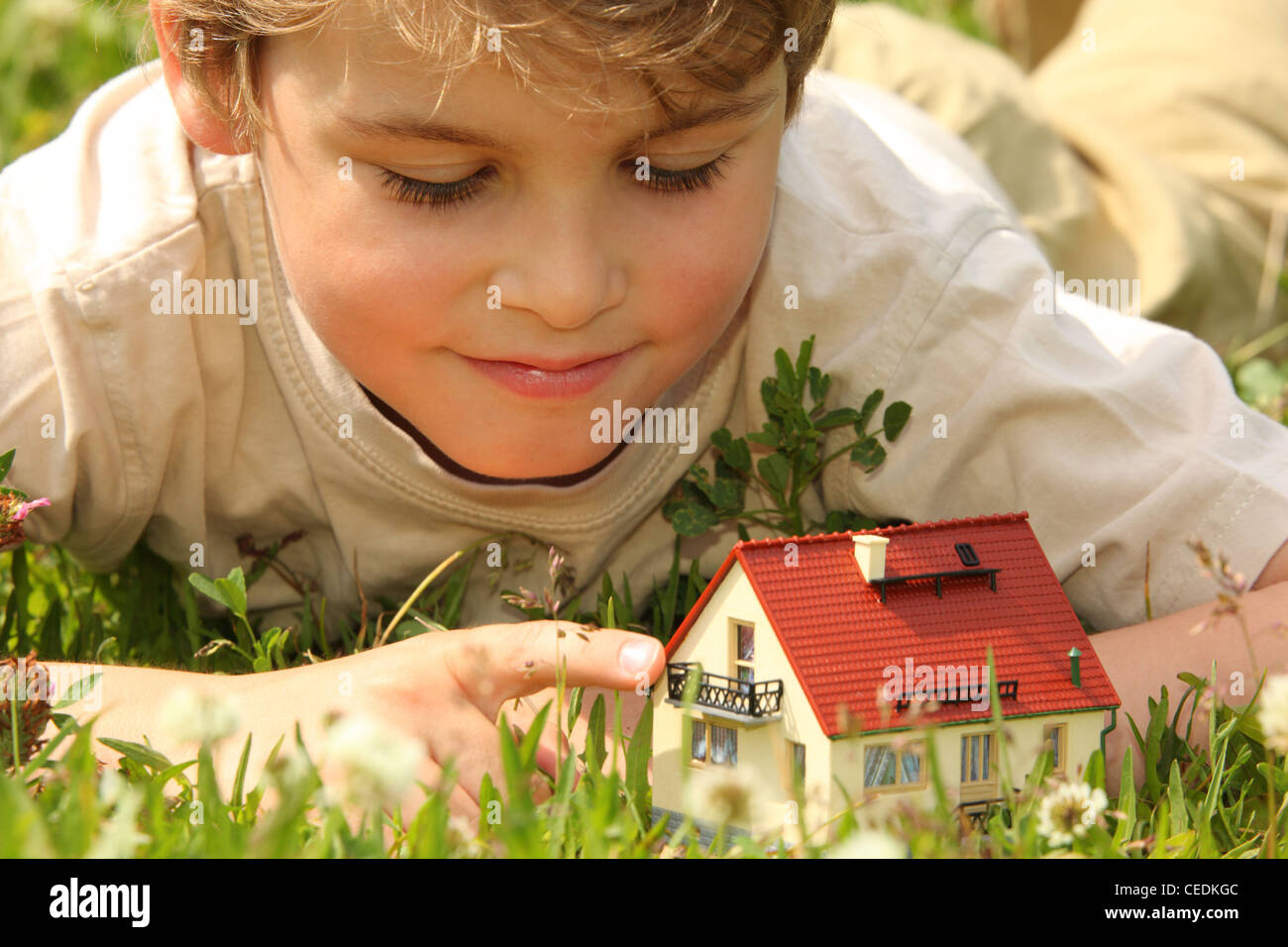 Ragazzo e modello di casa in erba Foto Stock