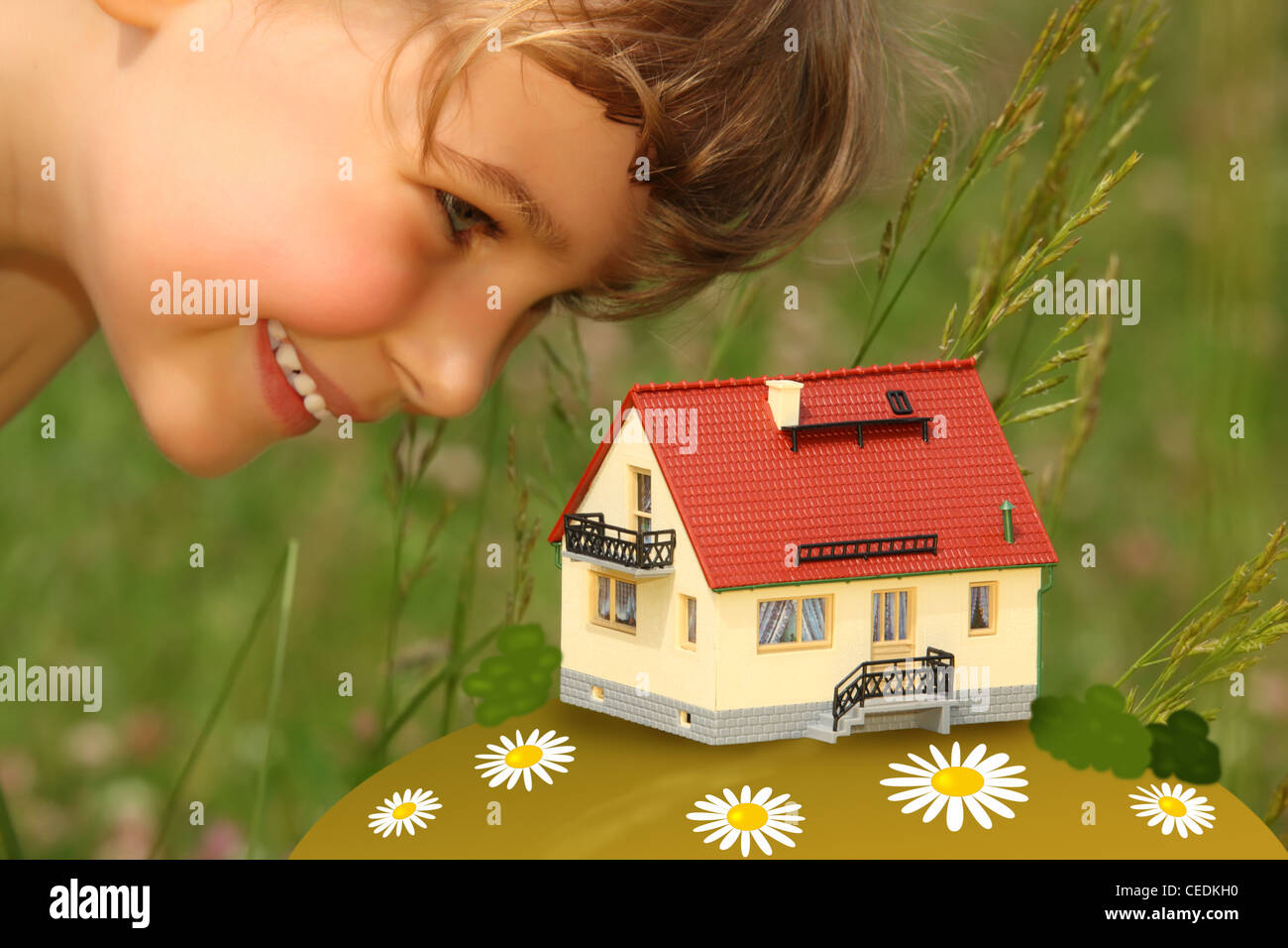 Bambino guarda sul modello di casa all'aperto Foto Stock