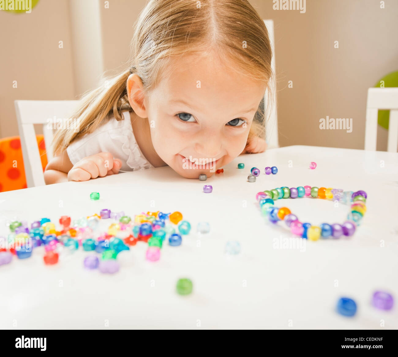 Ragazza caucasica stringing perline Foto Stock