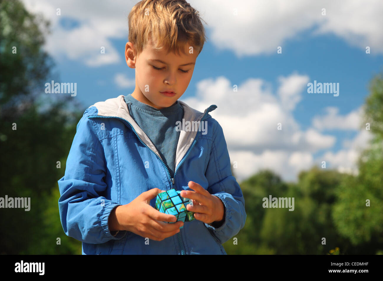 Ragazzo con terra Magia cubo all'aperto in estate Foto Stock