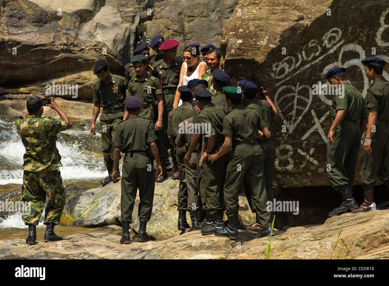 Sri Lanka soldati dell esercito della folla per una foto con la ragazza turistica a Rawana (Ravana) cade nel Ella Gap; Ella, Hill Country, Sri Lanka Foto Stock