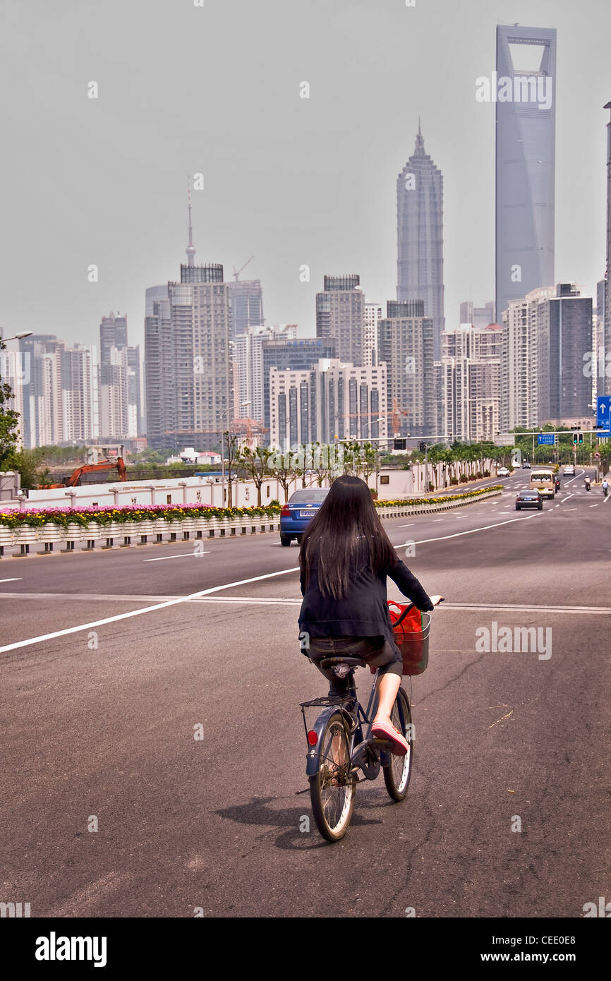 Giovani donne cinesi in sella ad una bicicletta a Shanghai Pudong - Cina Foto Stock