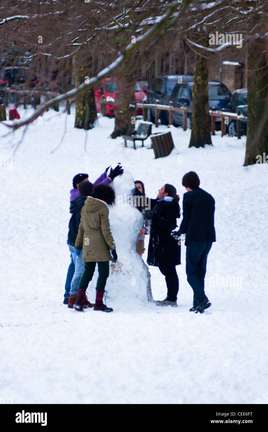 Facendo un pupazzo di neve a Parkers pezzo in inverno, Cambridge, Inghilterra. Foto Stock