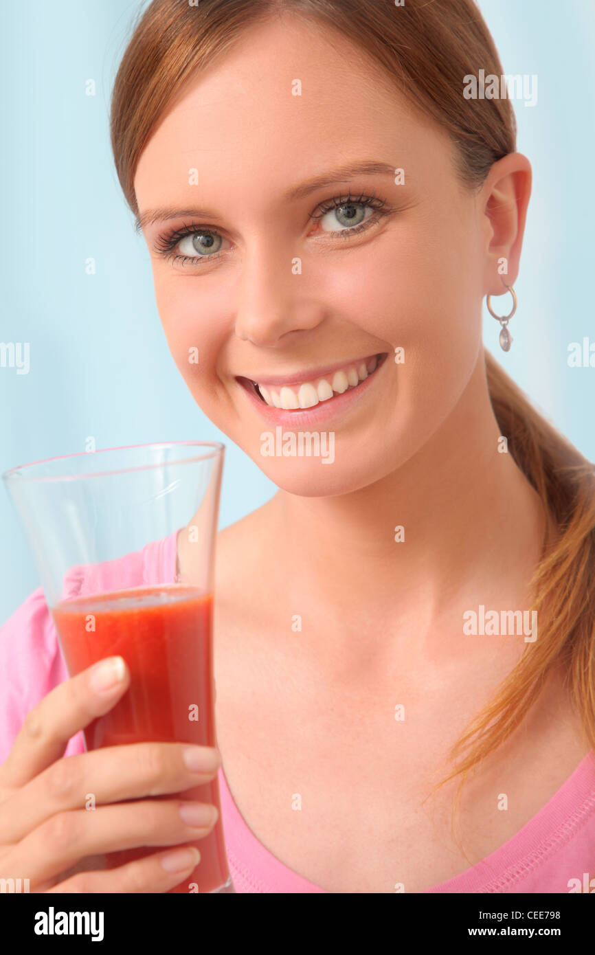 Giovane donna di bere il succo di pomodoro per la disintossicazione. Foto Stock