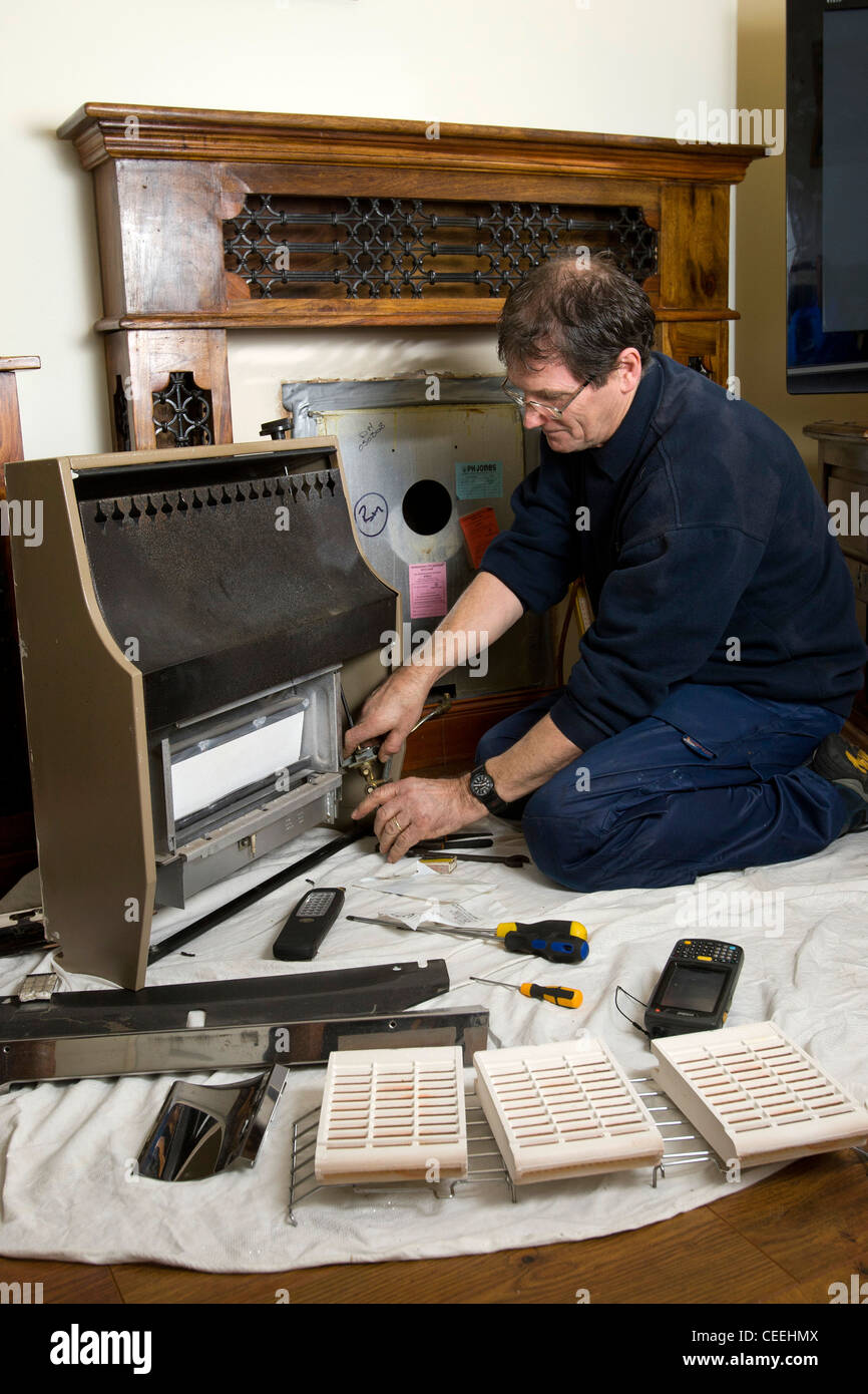 Un qualificato montatore di Gas controllo della installazione di un caminetto a gas in una casa nella Sala Verde, Birmingham, Regno Unito. Foto Stock