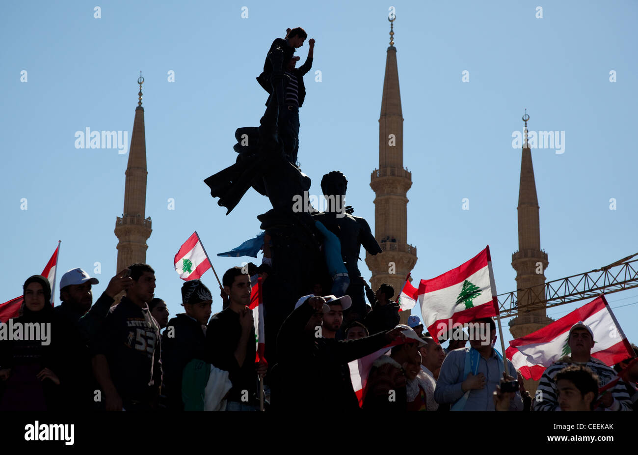 Sostenitori politici con le bandiere scavalcare Piazza Martiri monumento a Beirut, in Libano. Torre di minareti sulla scena Foto Stock