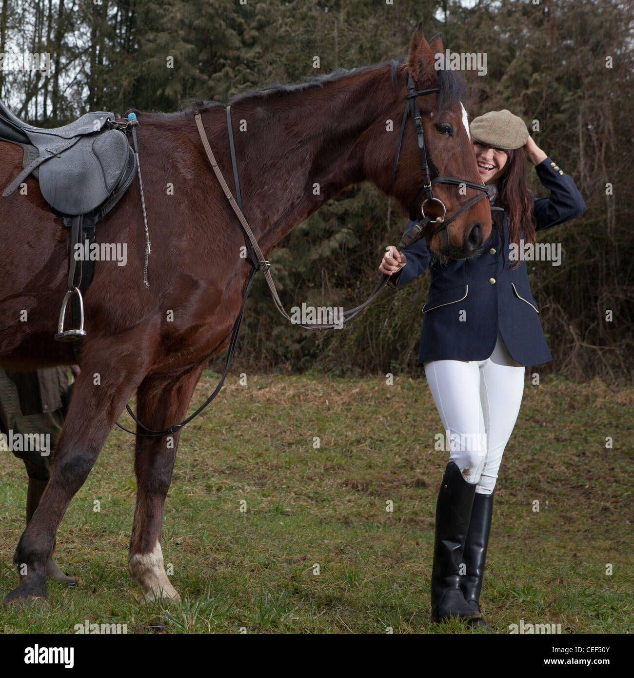 Giovane ragazza tenendo un cavallo attraverso un parco Foto Stock