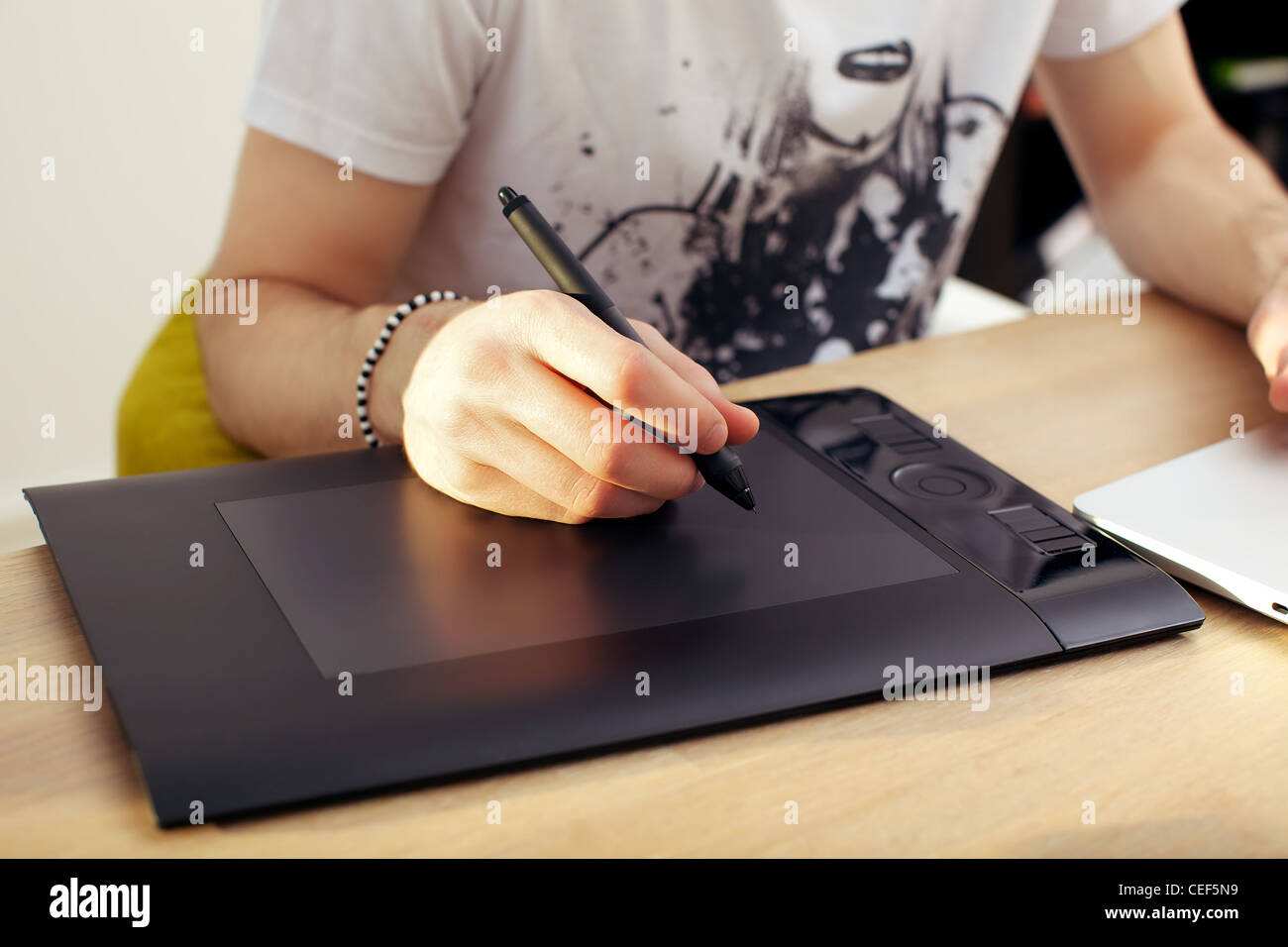 Primo piano di un mans mano che tiene la penna stylus su un touchpad tavoletta grafica. Foto Stock