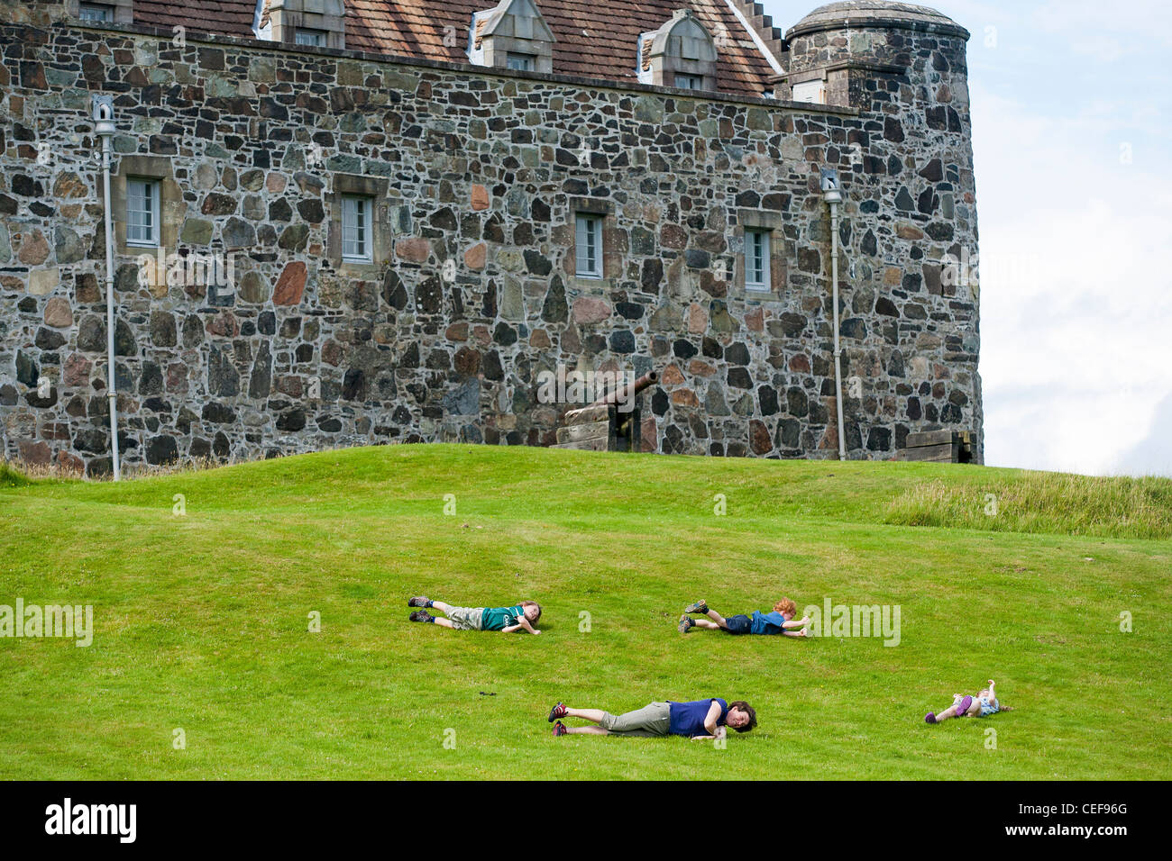 Una famiglia rotolare giù per il prato anteriore del Castello di Duart sull'Isle of Mull inn le Ebridi Interne della Scozia occidentale. Foto Stock