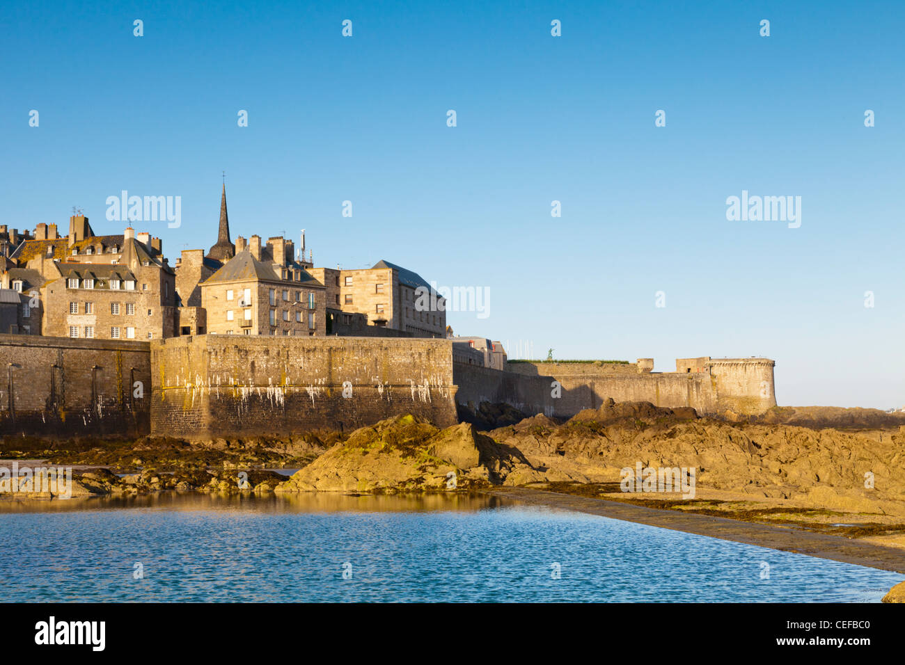 Spiaggia rocciosa a St-Malo, Bretagna, Francia, di fronte alla città vecchia e bastioni. Foto Stock