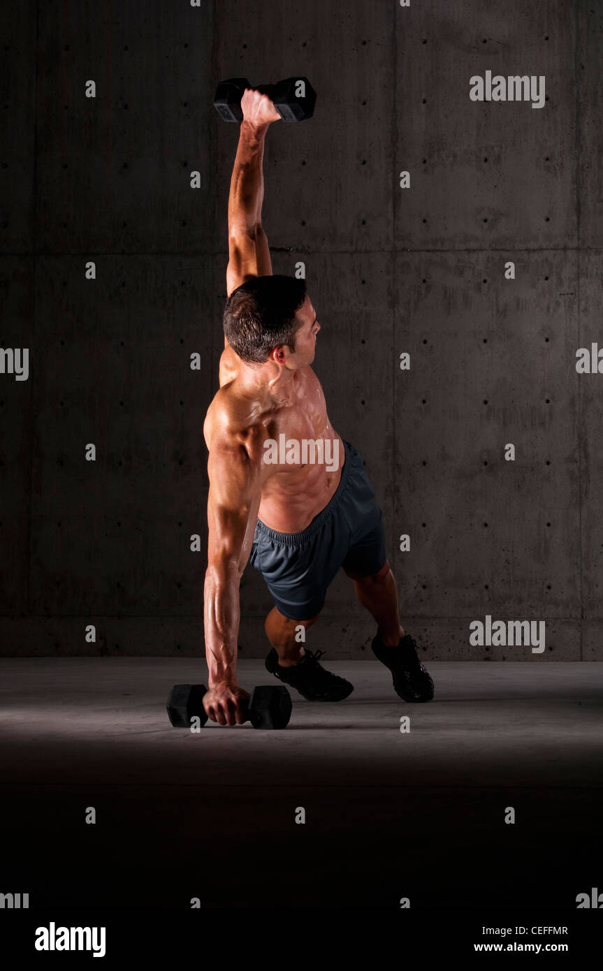 Atleta facendo ups push sui pesi Foto Stock