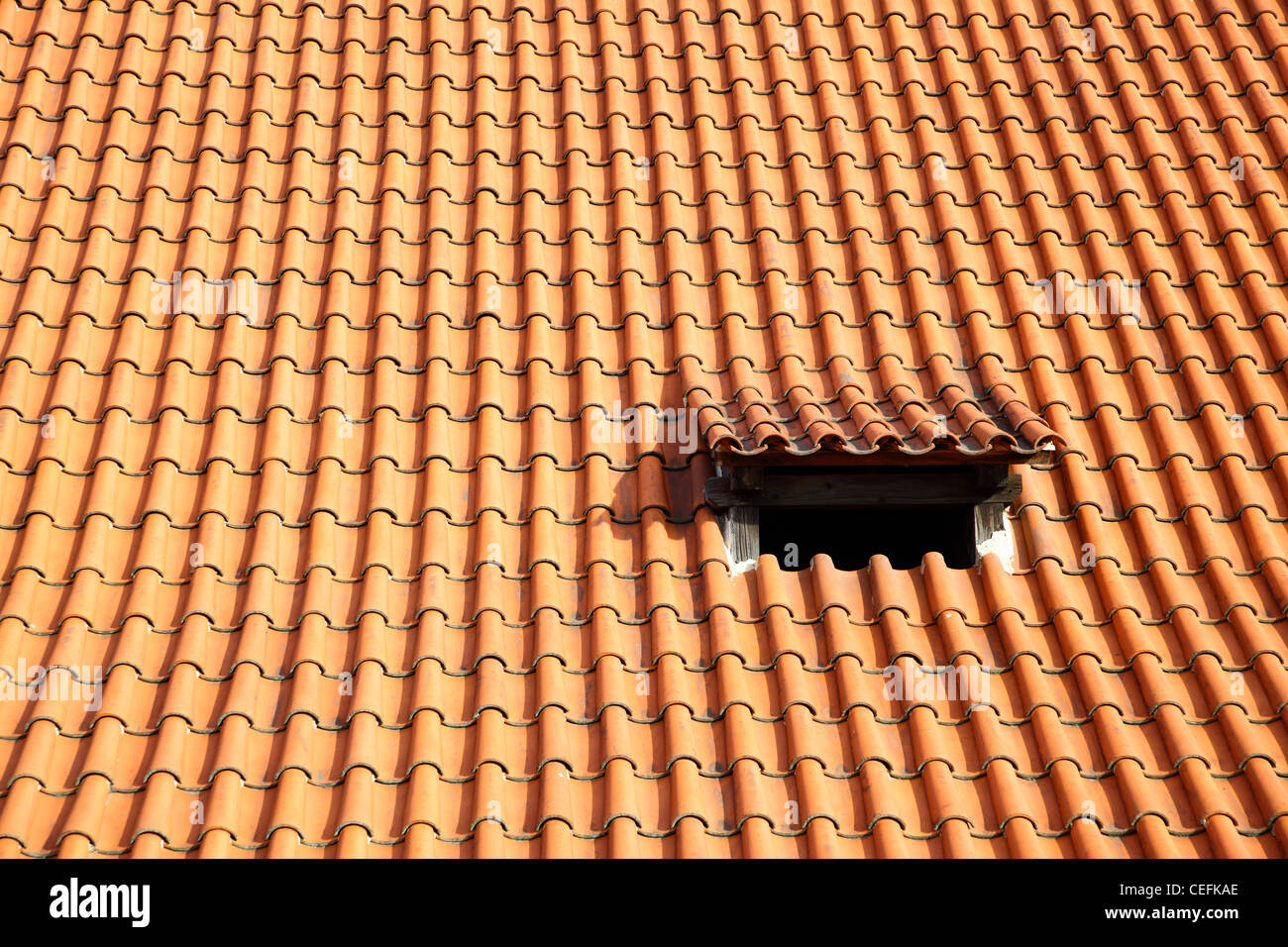 Il vecchio tetto di tegole rosse e con piccola finestra Foto Stock