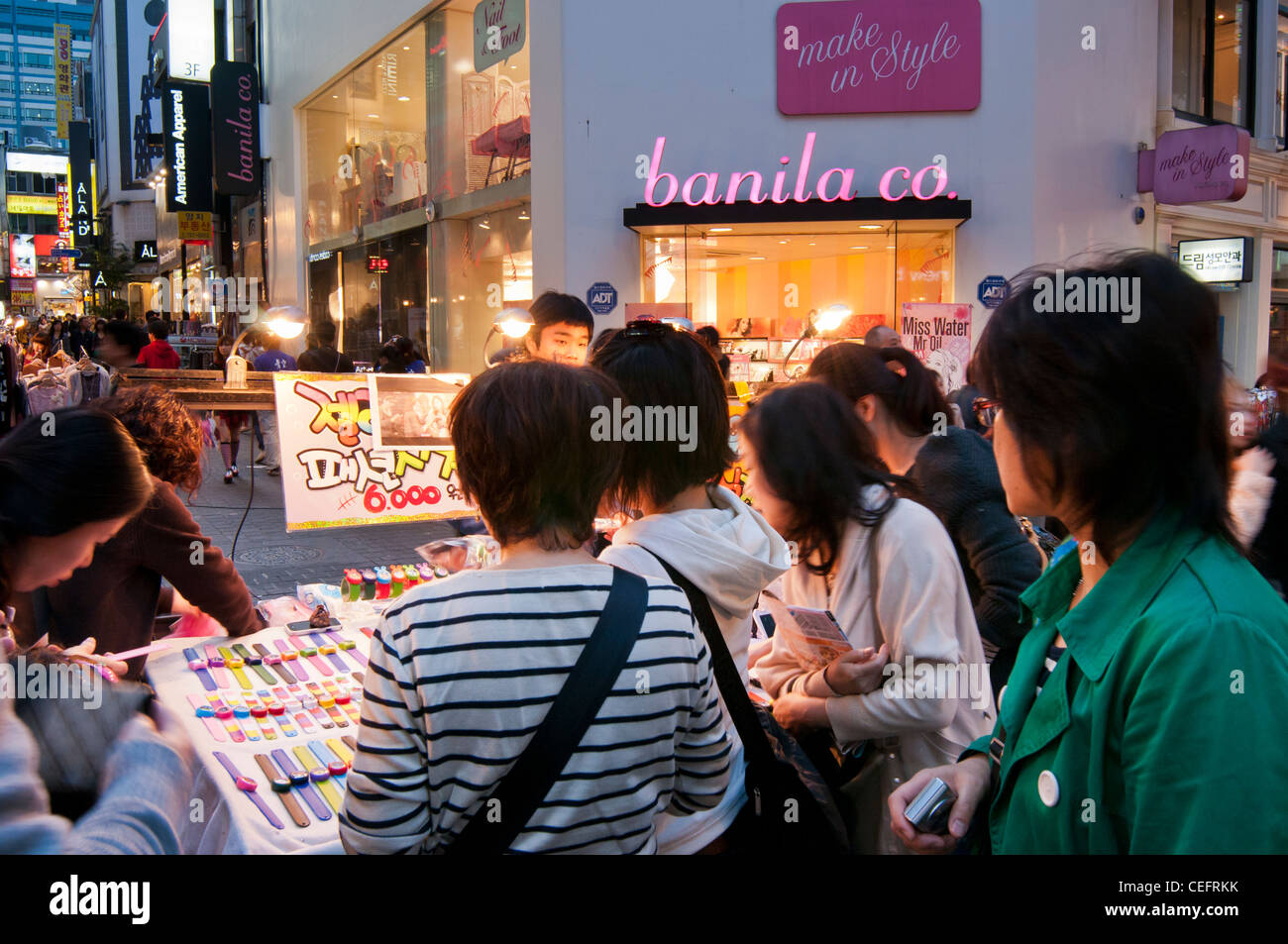 Gli amanti dello shopping acquisto di orologi da uno stallo nel famoso quartiere dello shopping di Myungdong a Seoul, Corea del Sud Foto Stock