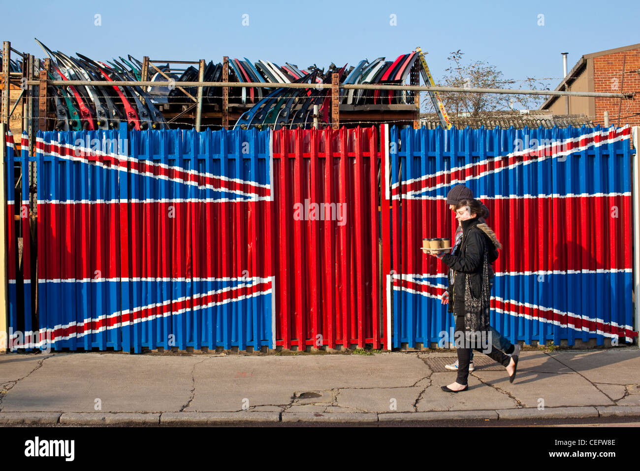 La gente a piedi passato una pittura patriottica della Union Jack sul business Industrial site Ingresso, Hackney Wick, a est di Londra - Inghilterra Foto Stock