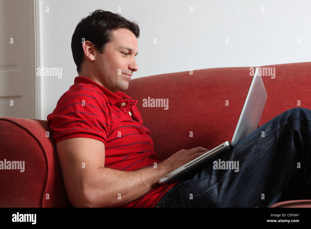 Profilo di un singolo uomo che utilizza un computer portatile. Foto Stock
