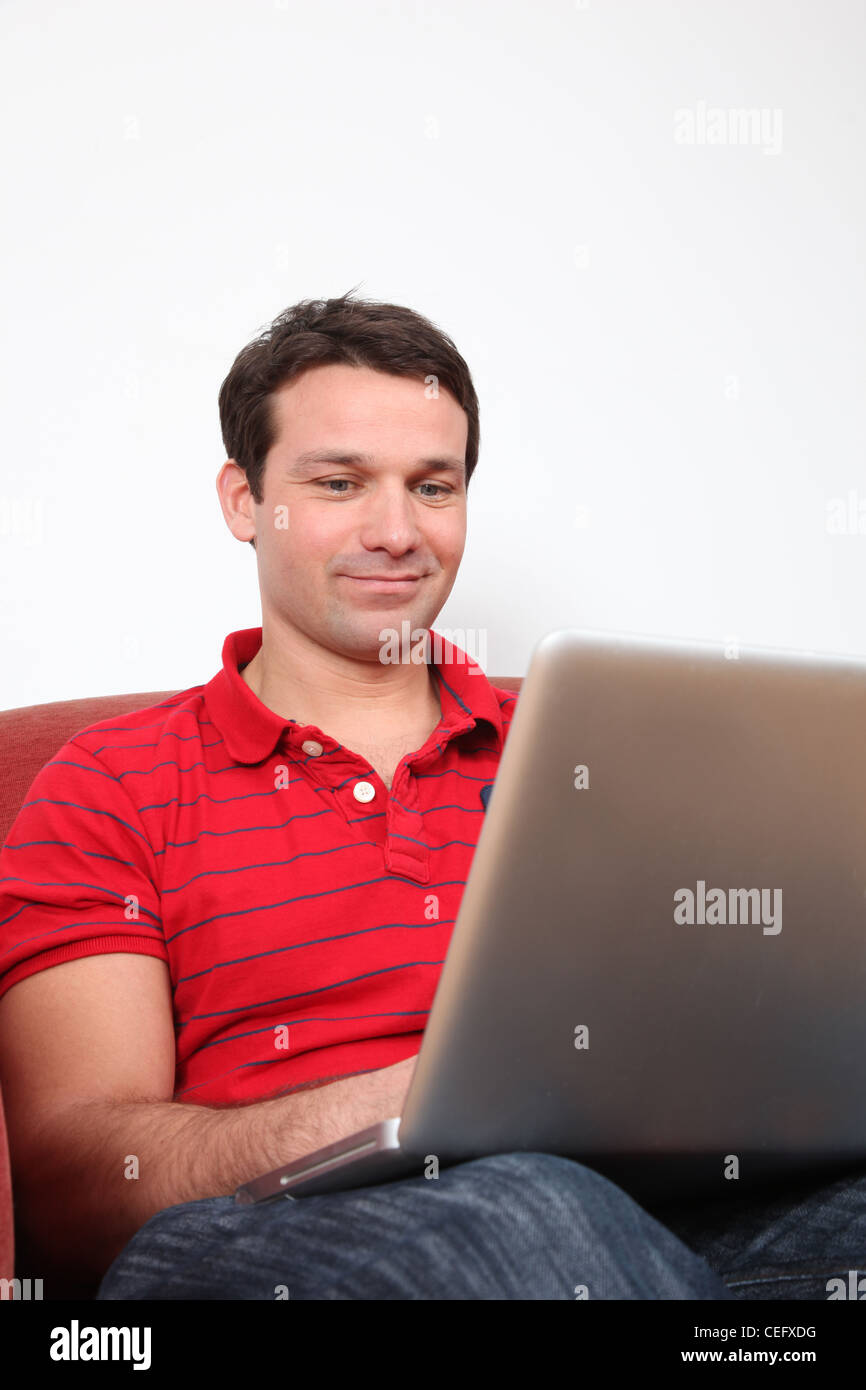 Profilo di un uomo sorridente con un computer portatile. Foto Stock
