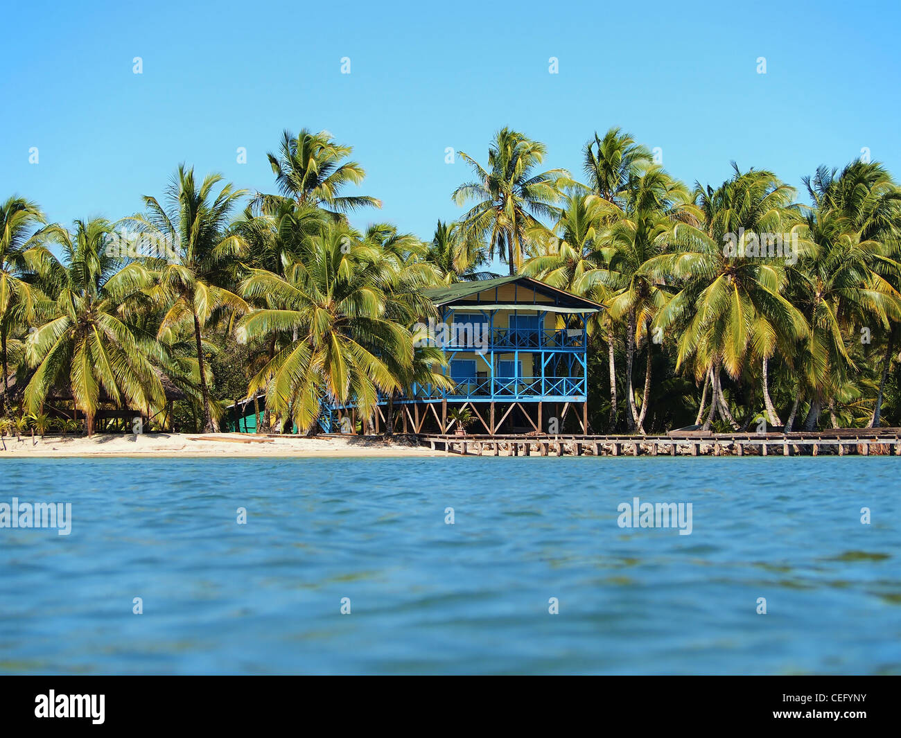 Casa sul lungomare su una spiaggia tropicale con palme da cocco e un dock, lato caraibico di Panama, America Centrale Foto Stock