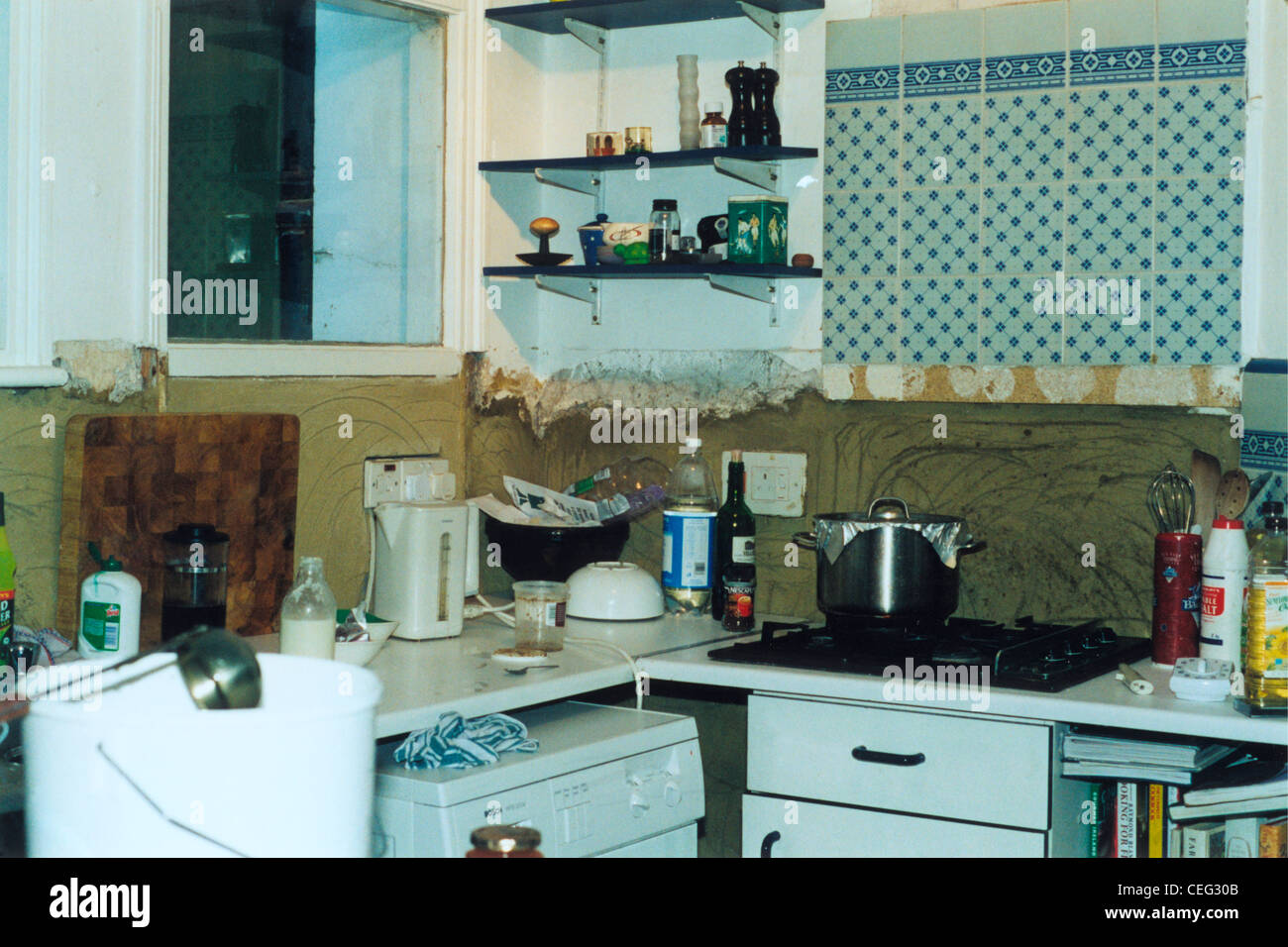 Ripiani in vetro al di sopra del piano di cottura e la lavastoviglie in cucina datata prima del rinnovamento Foto Stock