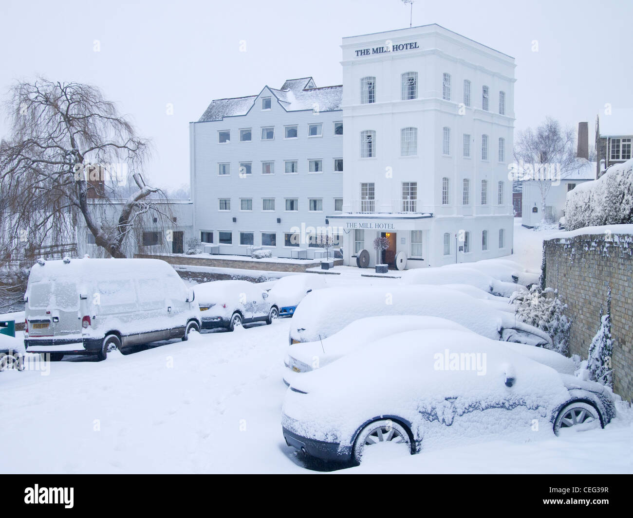 Coperte di neve macchine parcheggiate davanti al mulino Hotel occupa un edificio di Sudbury, Suffolk, Inghilterra. Foto Stock
