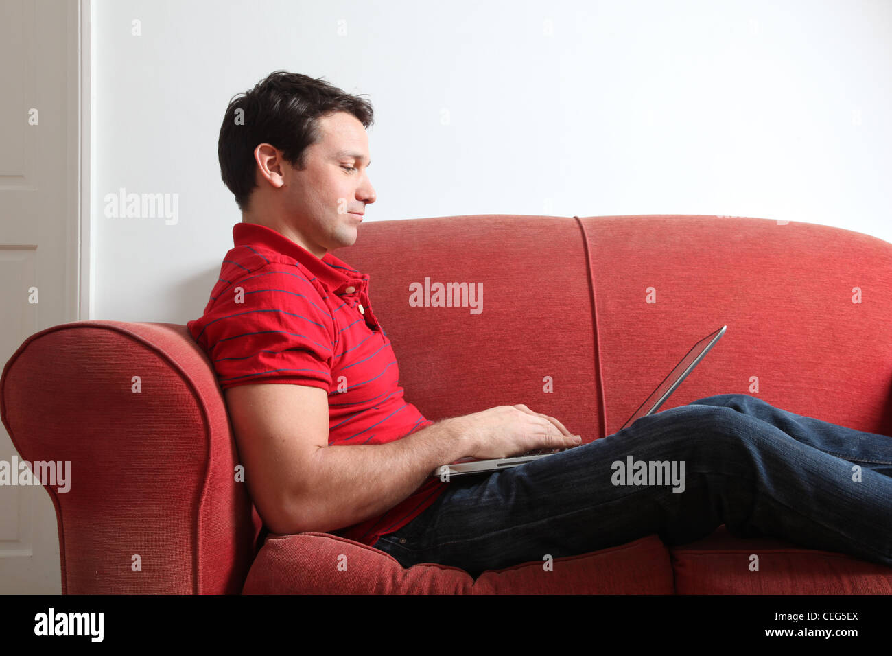 Profilo di un singolo uomo che utilizza un computer portatile. Foto Stock