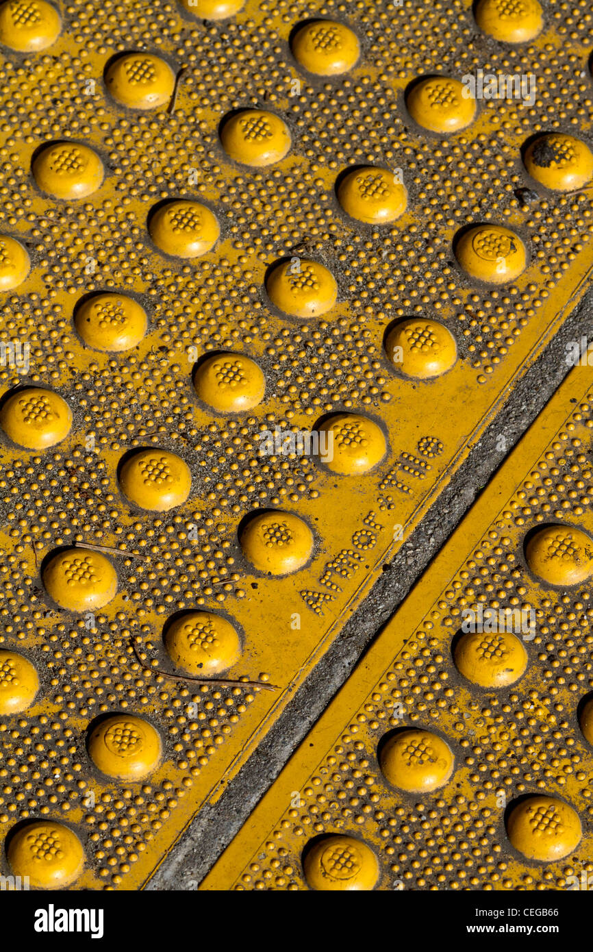 Giallo e costellato di pietre per pavimentazione in corrispondenza del bordo di un marciapiede in San Francisco, contrassegnato Arbor Tile Foto Stock