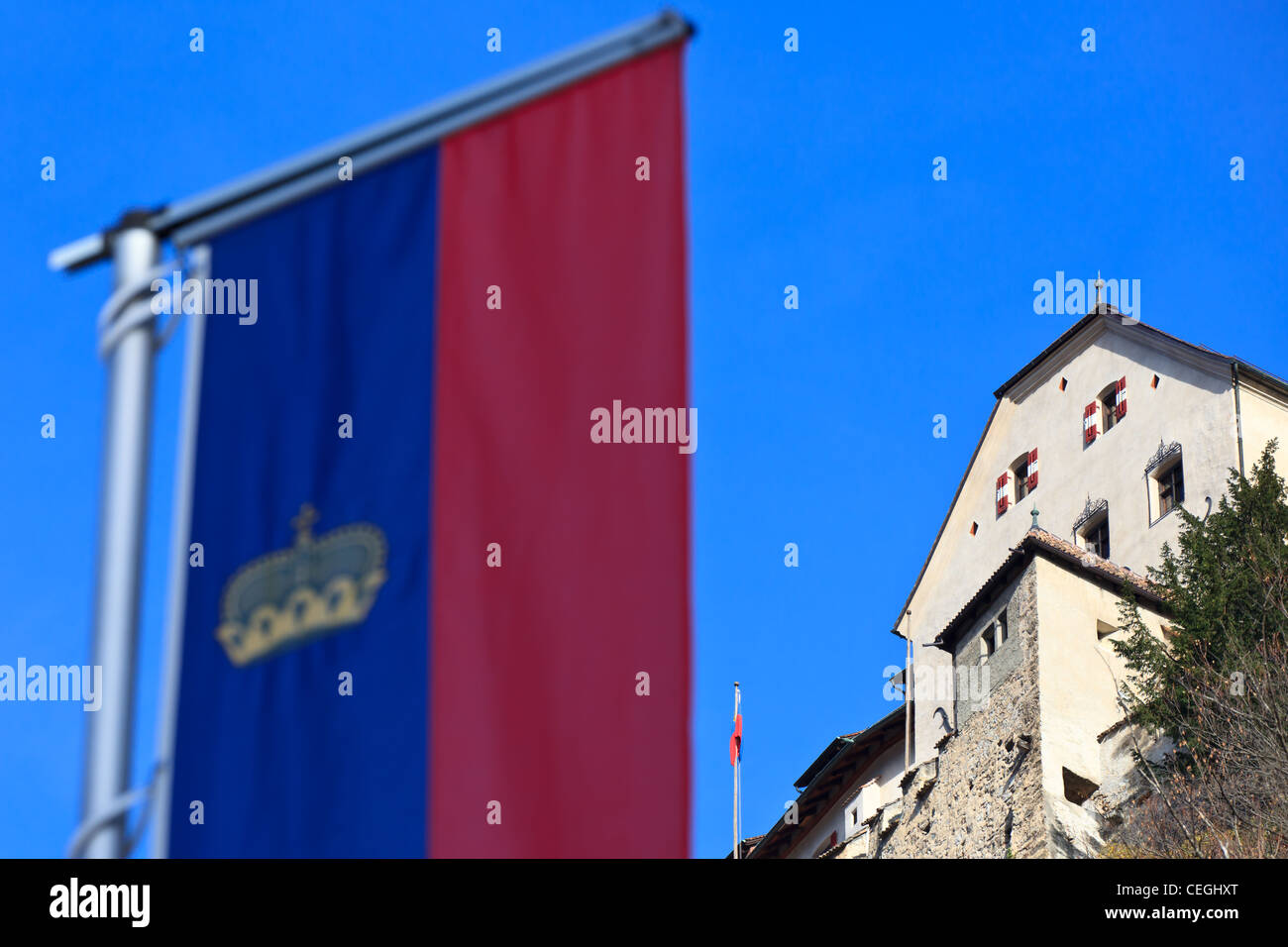 La bandiera ufficiale del Liechtenstein in primo piano e il castello di Vaduz in background, Liechtenstein Foto Stock