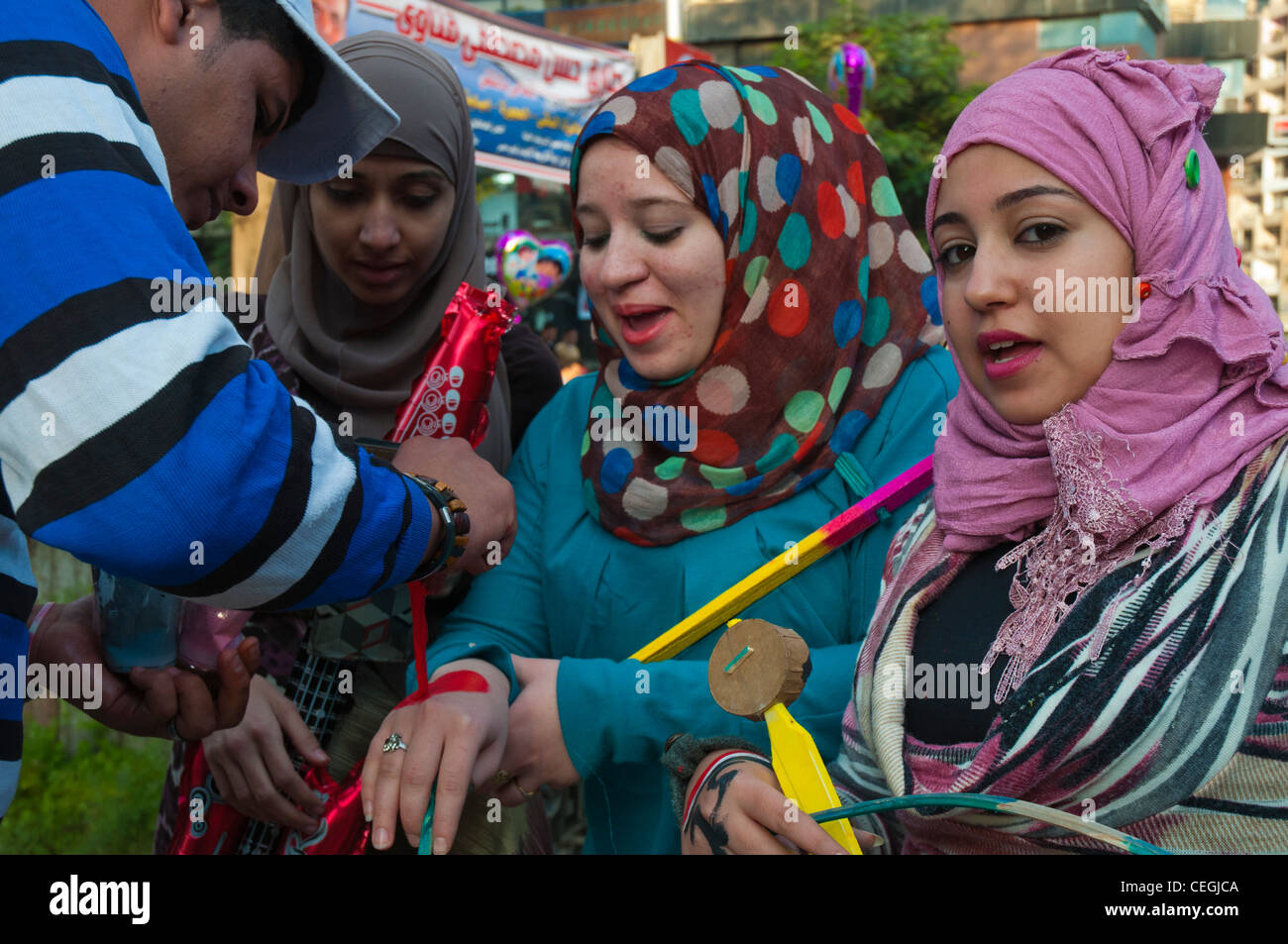 Adolescente ragazze ricevono faccia la vernice nei colori nazionali a Eid el Adha celebrazioni del Cairo in Egitto. Foto Stock