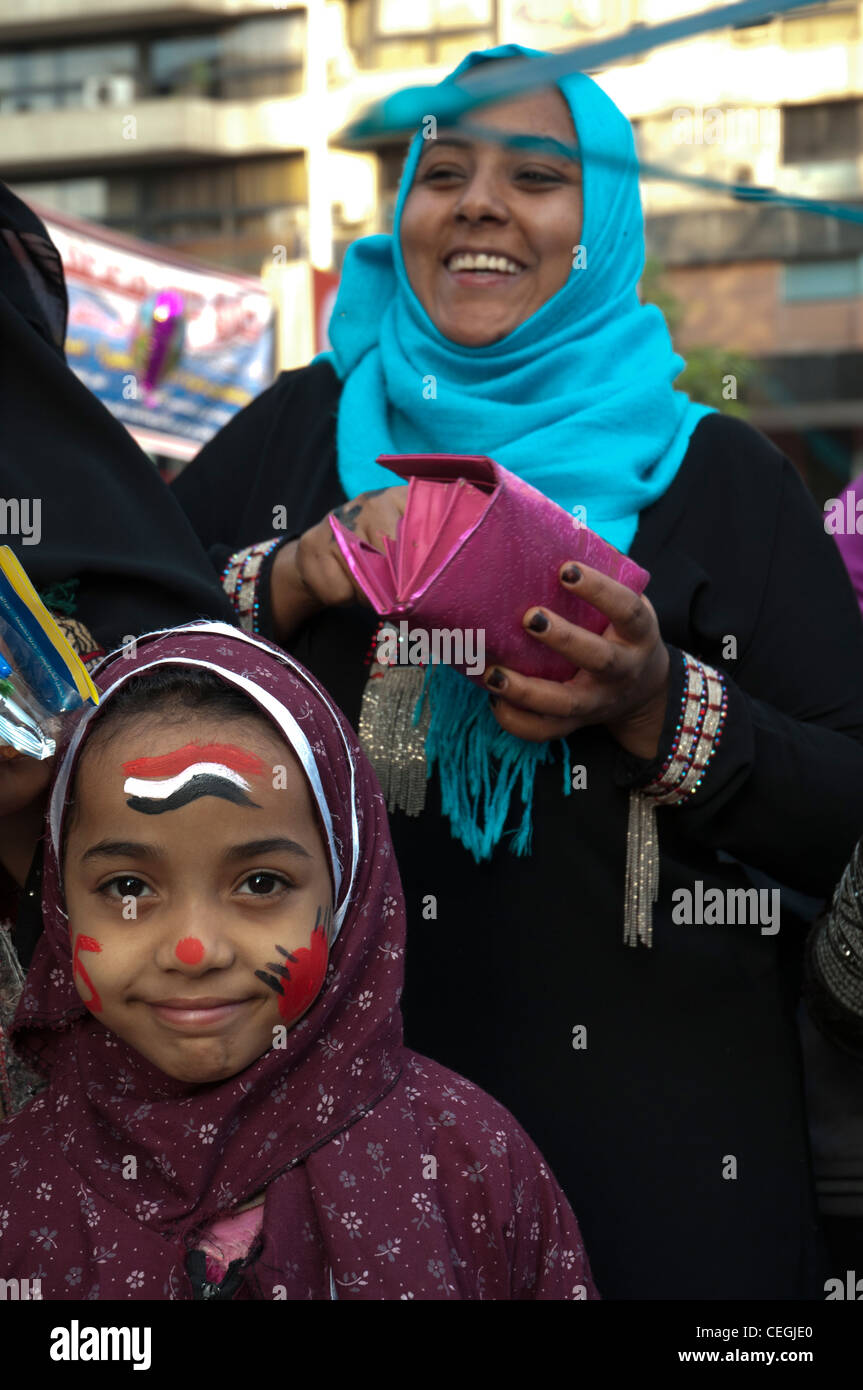 Ragazza giovane si consuma fresco-faccia applicata la vernice nei colori nazionali in occasione di Eid el Adha celebrazioni del Cairo in Egitto. Foto Stock