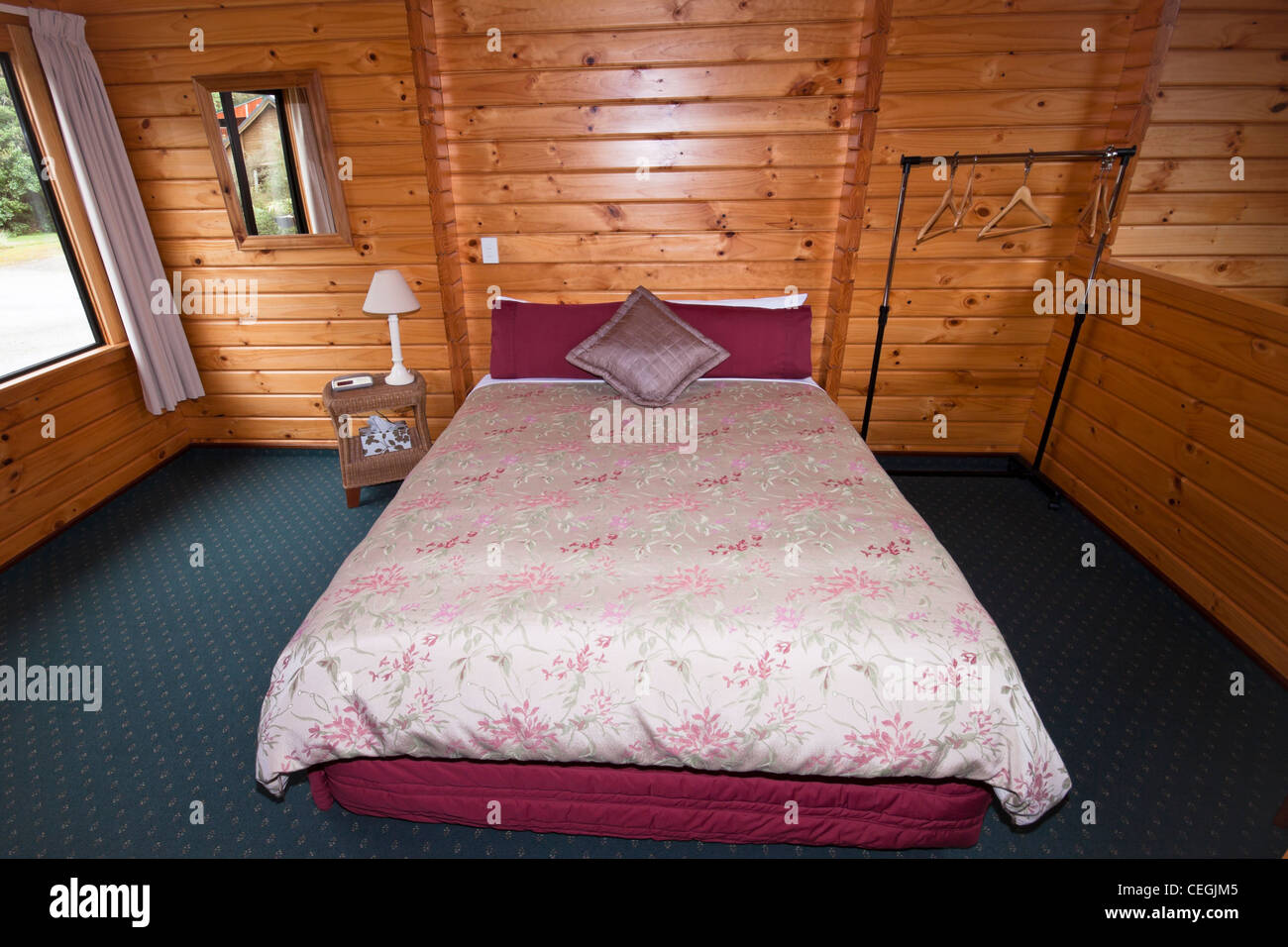 Bello e caldo interno del lodge in camera da letto. Fox Glacier Lodge, Fox Glacier, Costa Ovest, South Island, in Nuova Zelanda. Foto Stock