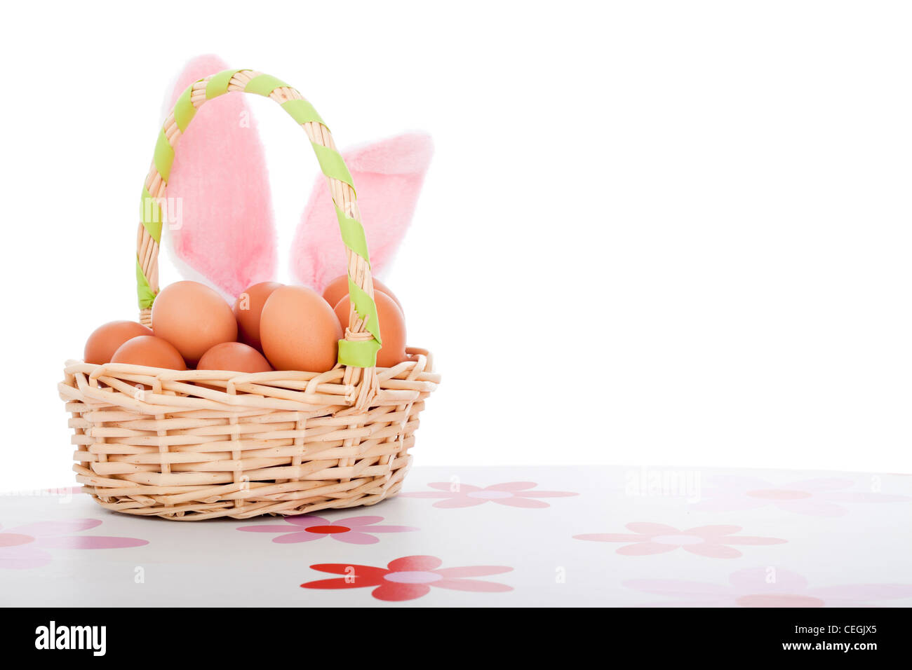 Cesto di pasqua con uova e orecchie di coniglietto di pasqua decorazione sfondo con copia spazio, isolati su sfondo bianco. Foto Stock