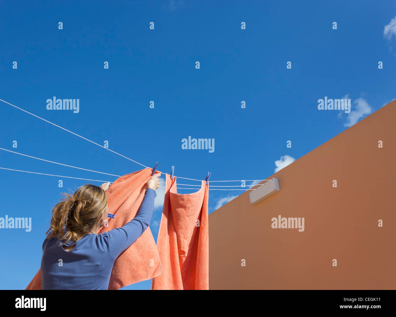 Giovane donna ancoraggio fuori il lavaggio a secco. Foto Stock