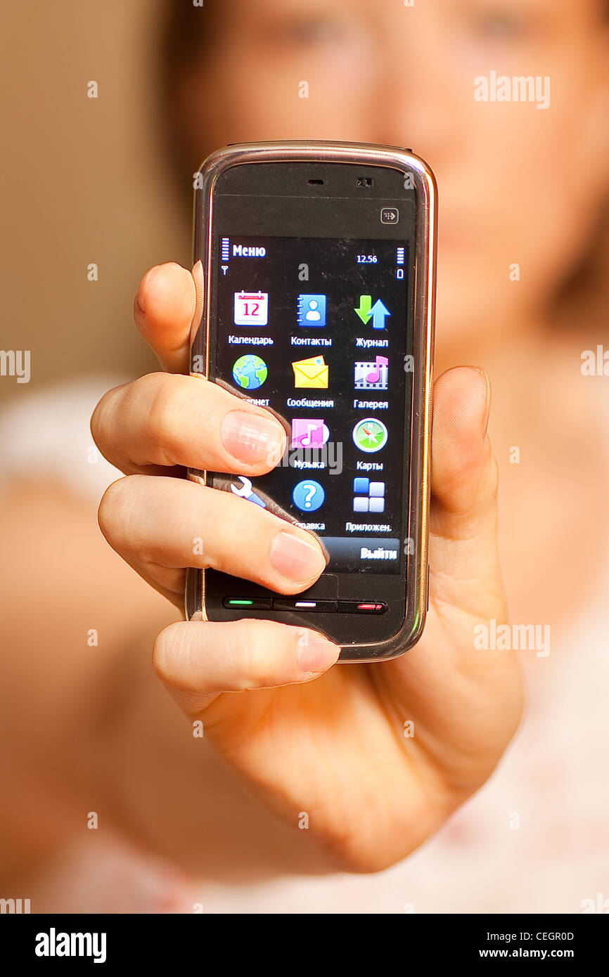 La donna che mostra il display del touch mobile cellulare Foto Stock