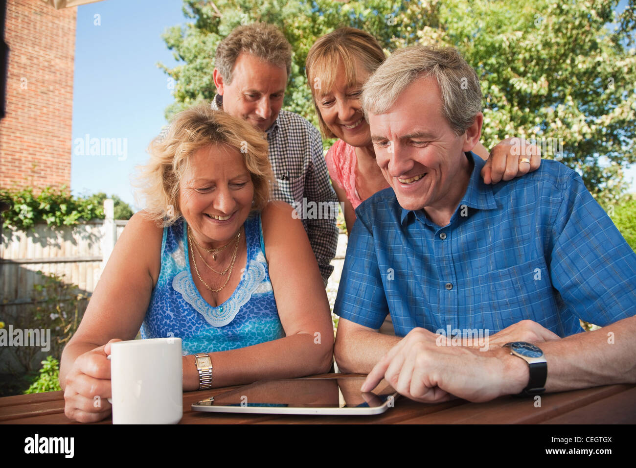 Senior e coppia amici guardando a tavoletta digitale all'aperto Foto Stock
