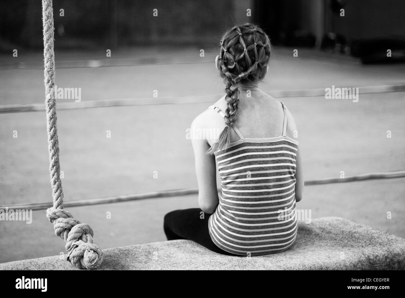 Ragazza giovane con trecce seduta dopo formazione di ginnastica. Foto Stock