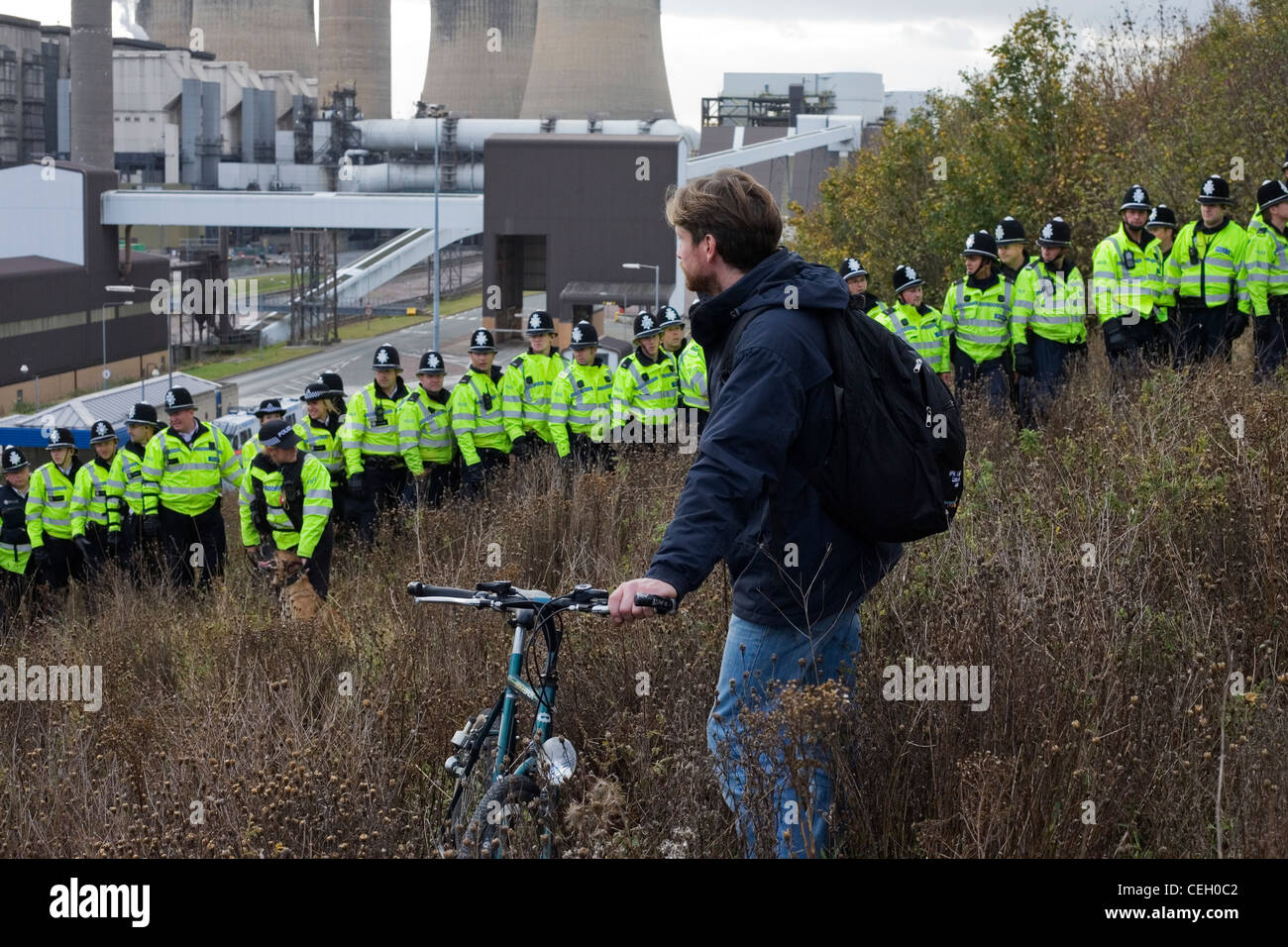 L'uomo con la bicicletta e bollitore di polizia a Ratcliffe su Soar Power Station clima protesta in picchiata. Foto Stock