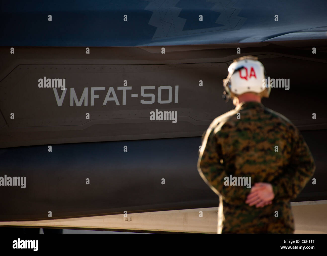 Un manutentore di Marine Fighter Attack Squadron 501 si erge mentre il primo combattente per sciopero congiunto della variante marina F-35B Lightning II è stato marshallato in posizione davanti allo squadrone della base dell'aeronautica di Eglin, la Fla. I Marines di VMFAT-501 hanno ricevuto due F-35B, gennaio 11. Entrambi gli aeromobili sono stati scortati da Marine F-18 Hornets. Foto Stock