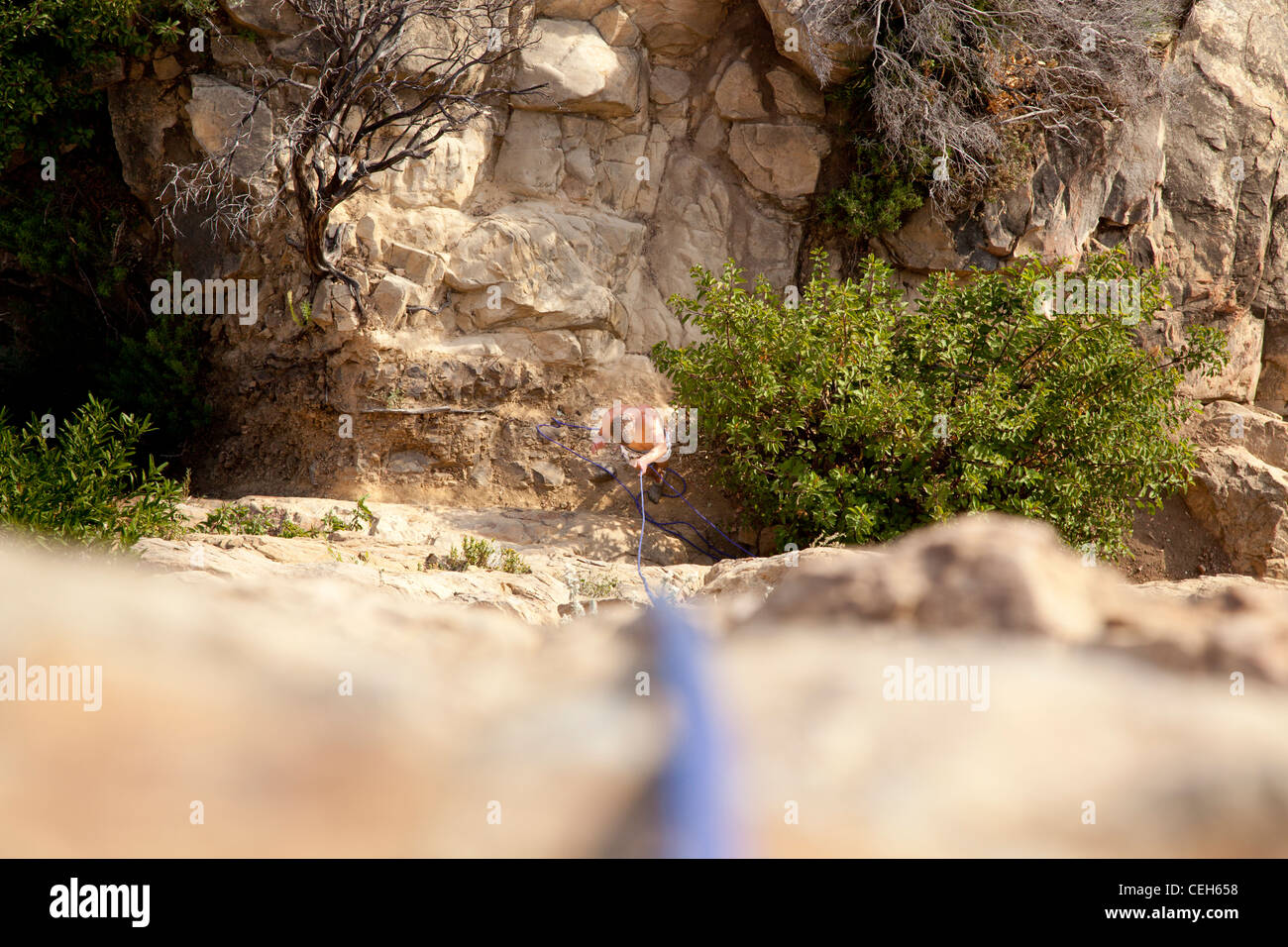 Uomo in procinto di salire la parete di roccia. Foto Stock