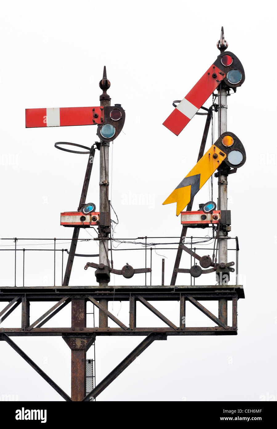 Primo piano su Inglese tradizionale con semaforo segnali ferroviari su gantry su sfondo bianco Foto Stock