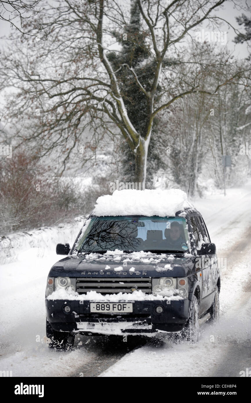 Una Range Rover 4x4 negozia una collina in condizioni di neve nel GLOUCESTERSHIRE REGNO UNITO Foto Stock