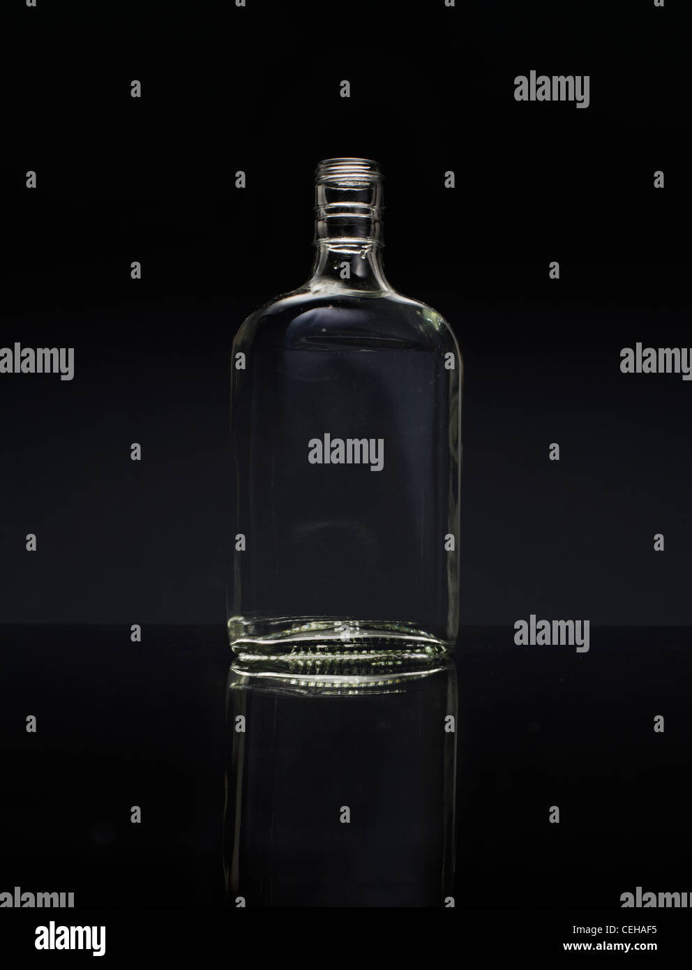 Bottiglia di vetro sulla superficie nera. Foto Stock