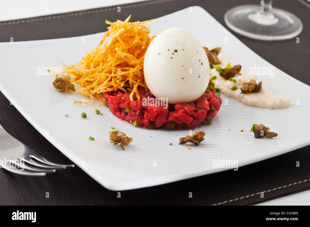 Piatto Gourmet con uova e carne cruda. Studio shot. Foto Stock