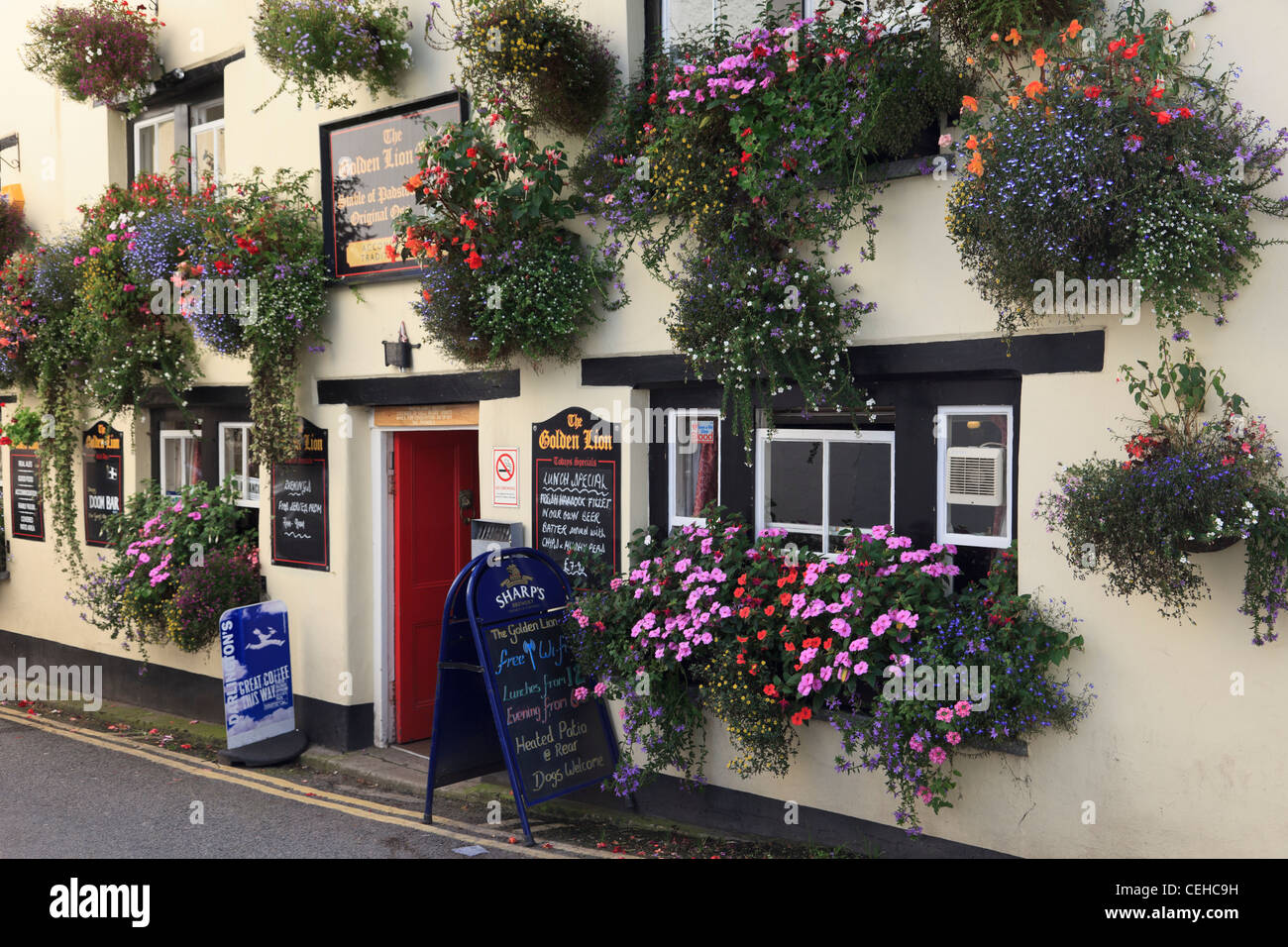 Padstow, Cornwall, Inghilterra, Regno Unito. Il Golden Lion pub fronte con fiori in cestelli appesi e fiore di piantatrici Foto Stock