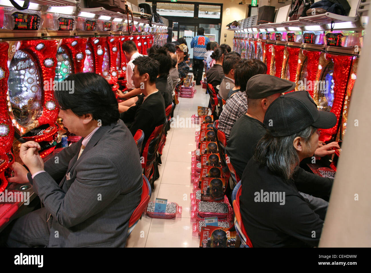 Gli uomini siedono in righe, riproduzione di Pachinko, Tokyo Giappone. 2011 Foto Stock